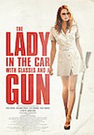 La dame dans l'auto avec des lunettes et un fusil